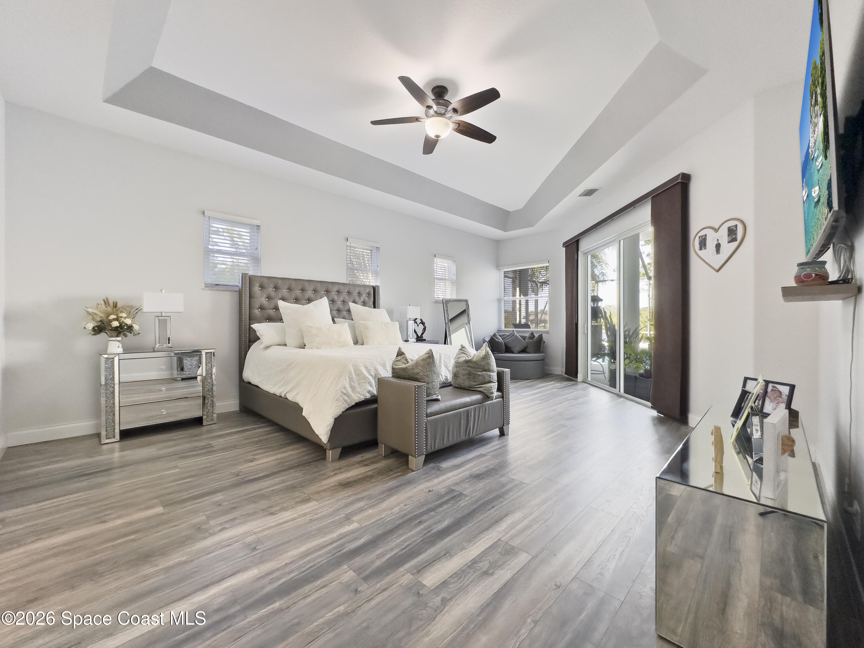 4762 Blossom Ridge Place Grant, FL 32949 - Photo 14 of 42 a spacious bedroom with a bed a couch and a chandelier
