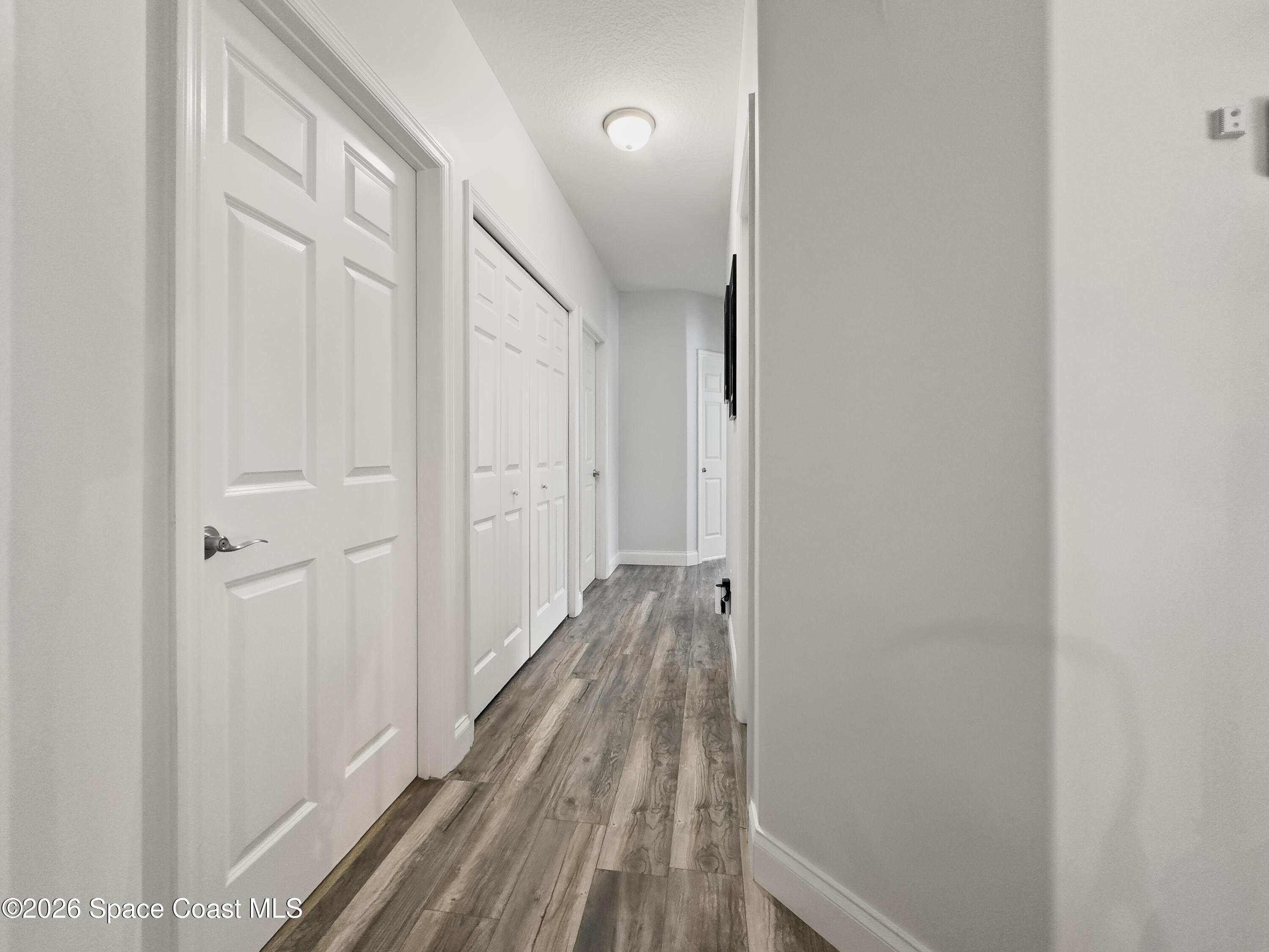 4762 Blossom Ridge Place Grant, FL 32949 - Photo 25 of 42 a view of a hallway with wooden floor and a bathroom