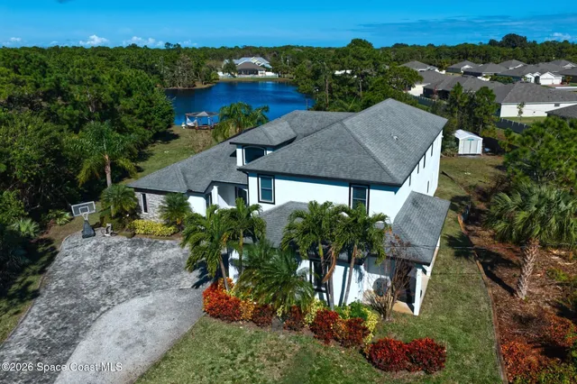a view of a house with a yard and potted plants