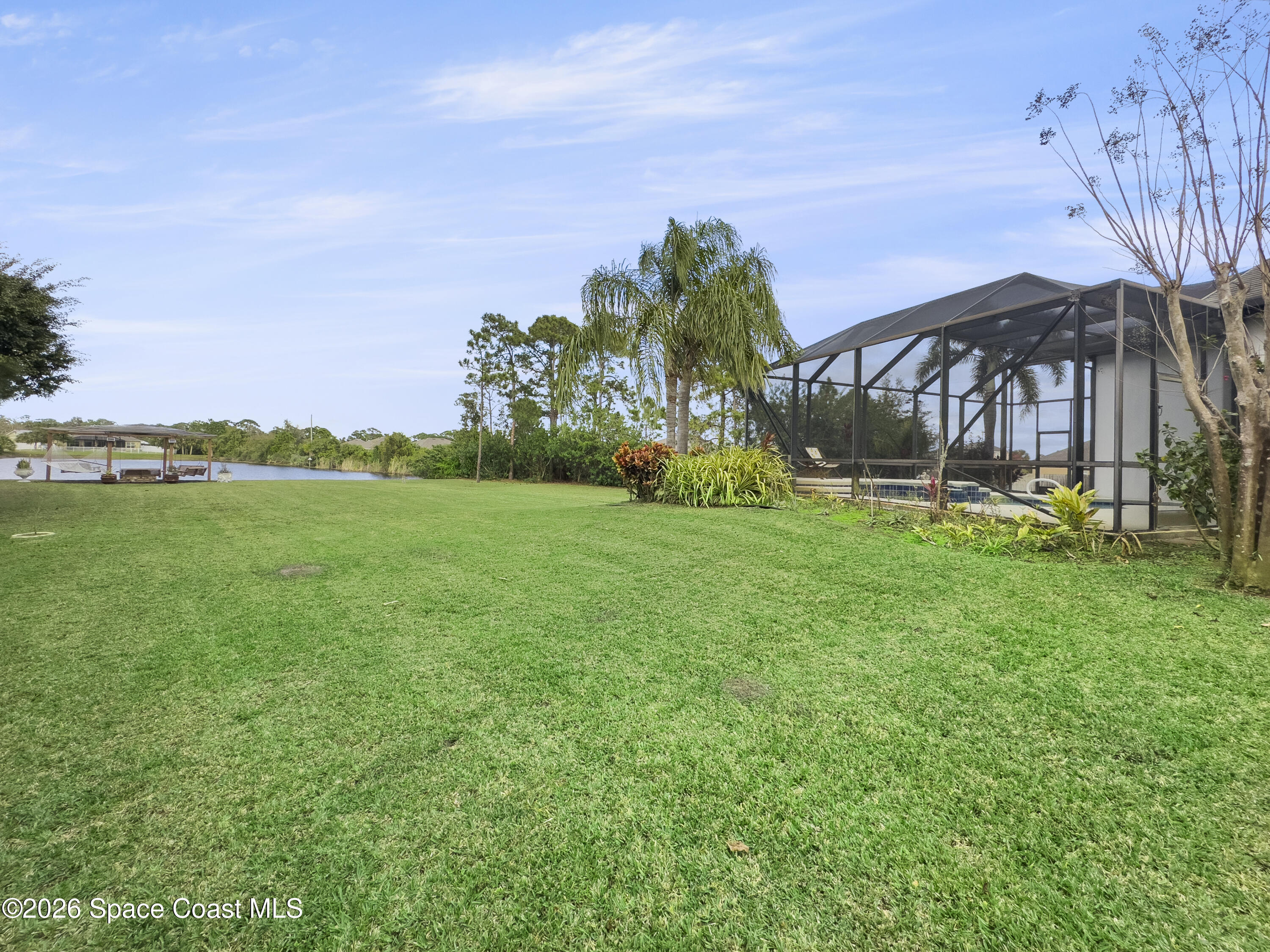 4762 Blossom Ridge Place Grant, FL 32949 - Photo 38 of 42 a backyard of a house with lots of green space and lake view