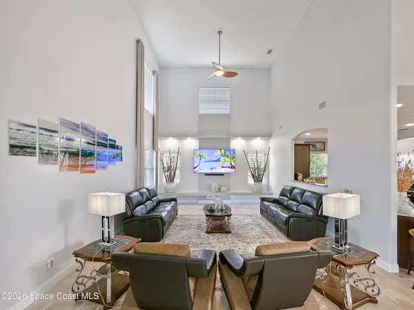 a spacious bedroom with a bed a couch and a chandelier