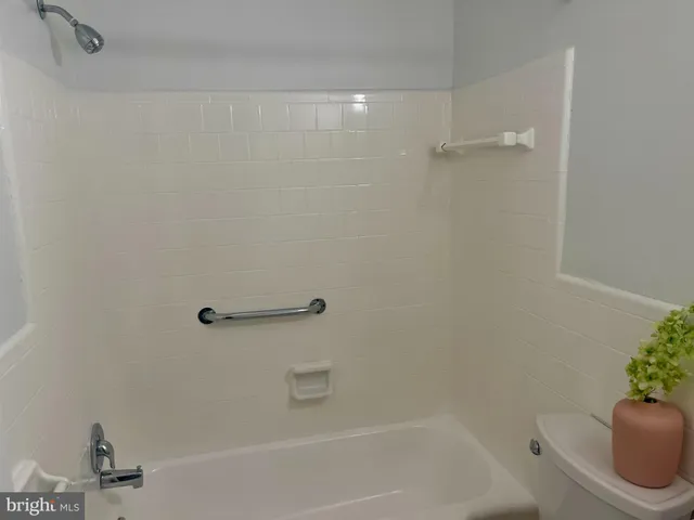 a view of an empty room with window and chandelier fan