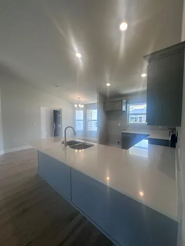 a kitchen with kitchen island a sink dishwasher a stove and a refrigerator with wooden floor