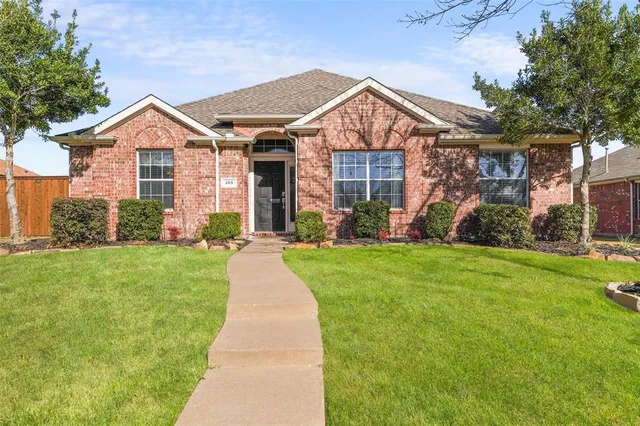 a front view of a house with a yard and many windows