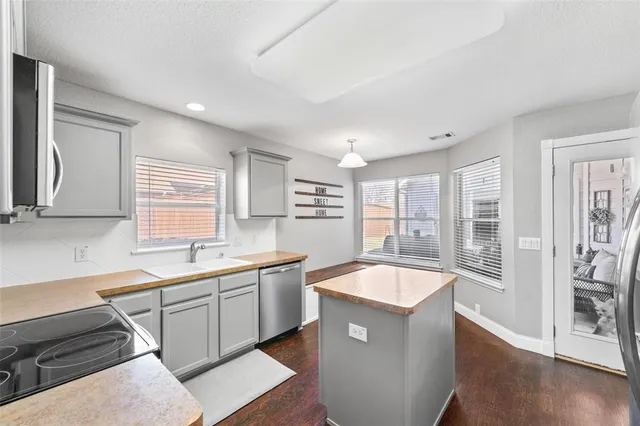 a kitchen with granite countertop a refrigerator and a sink