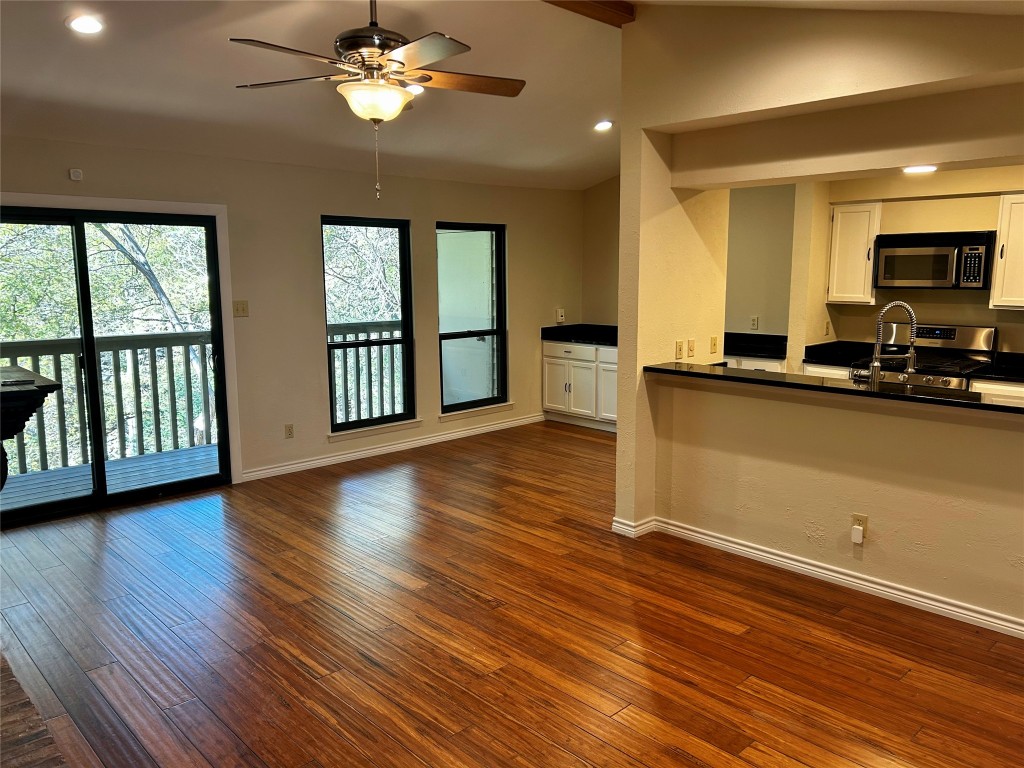 a view of a livingroom with furniture a ceiling fan and window