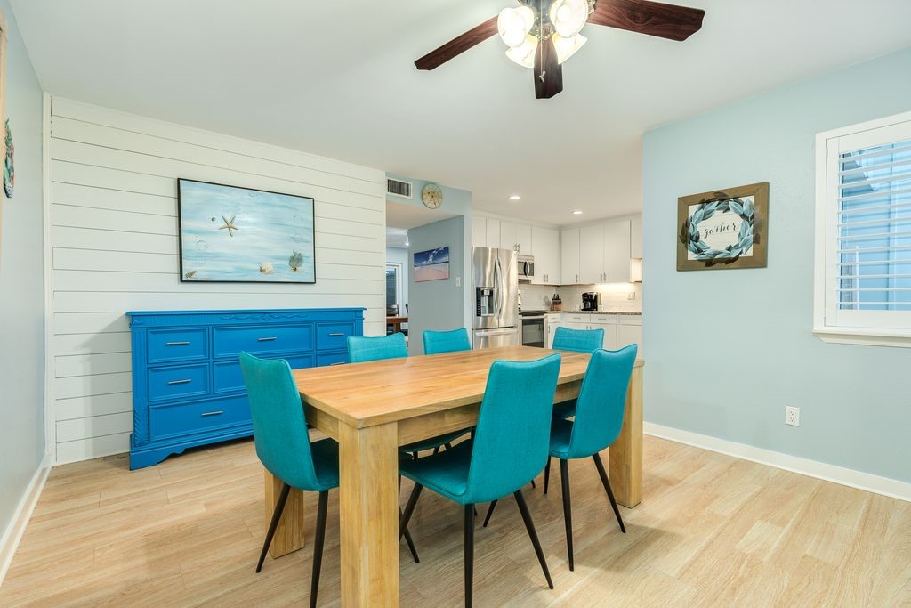 7516 Stewart Road Galveston, TX 77551 - Photo 12 of 25 a view of a dining room with furniture and a chandelier fan