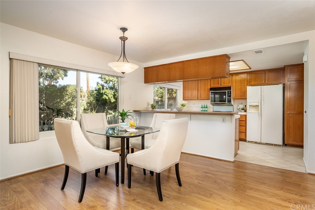 7951 Waterfall Circle Huntington Beach, CA 92648 - Photo 17 of 40 a dining room with furniture a chandelier and wooden floor