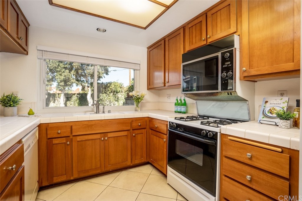 7951 Waterfall Circle Huntington Beach, CA 92648 - Photo 8 of 40 a kitchen with stainless steel appliances a stove sink and microwave