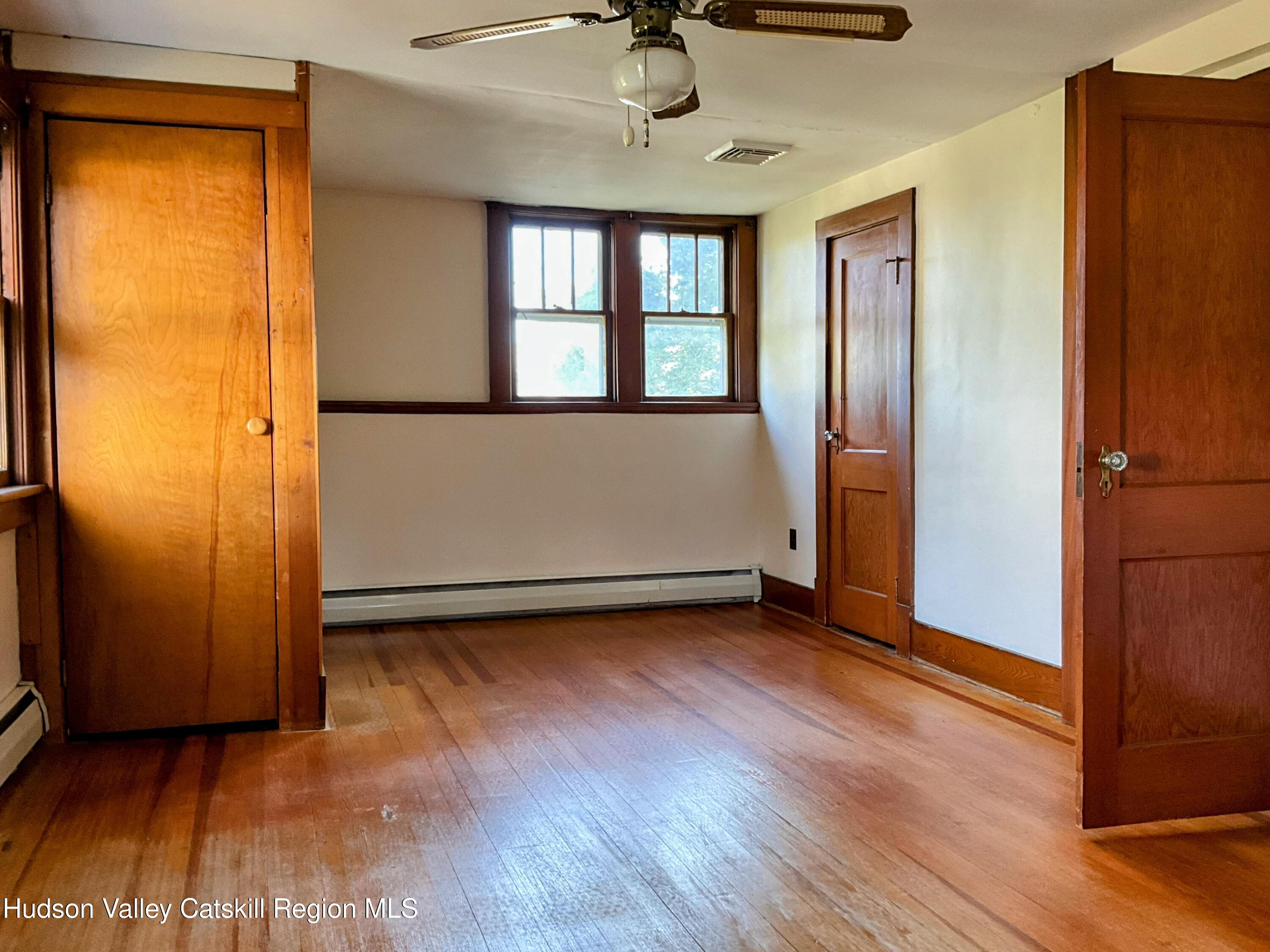729 Springtown Road Tillson, NY 12486 - Photo 23 of 52 an empty room with wooden floor cabinet and windows