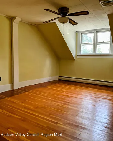 a view of a room with wooden floor and a cabinet