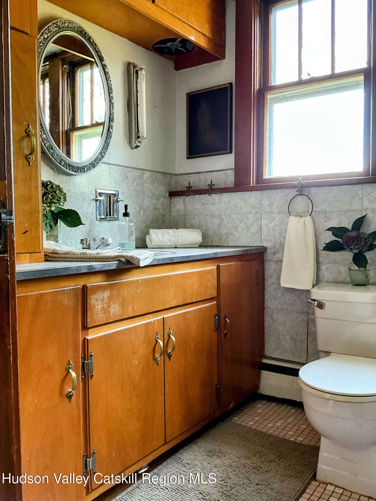729 Springtown Road Tillson, NY 12486 - Photo 27 of 52 a bathroom with a toilet a sink and a mirror