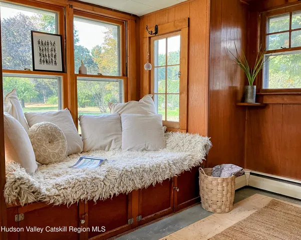a living room with furniture a piano and a potted plant