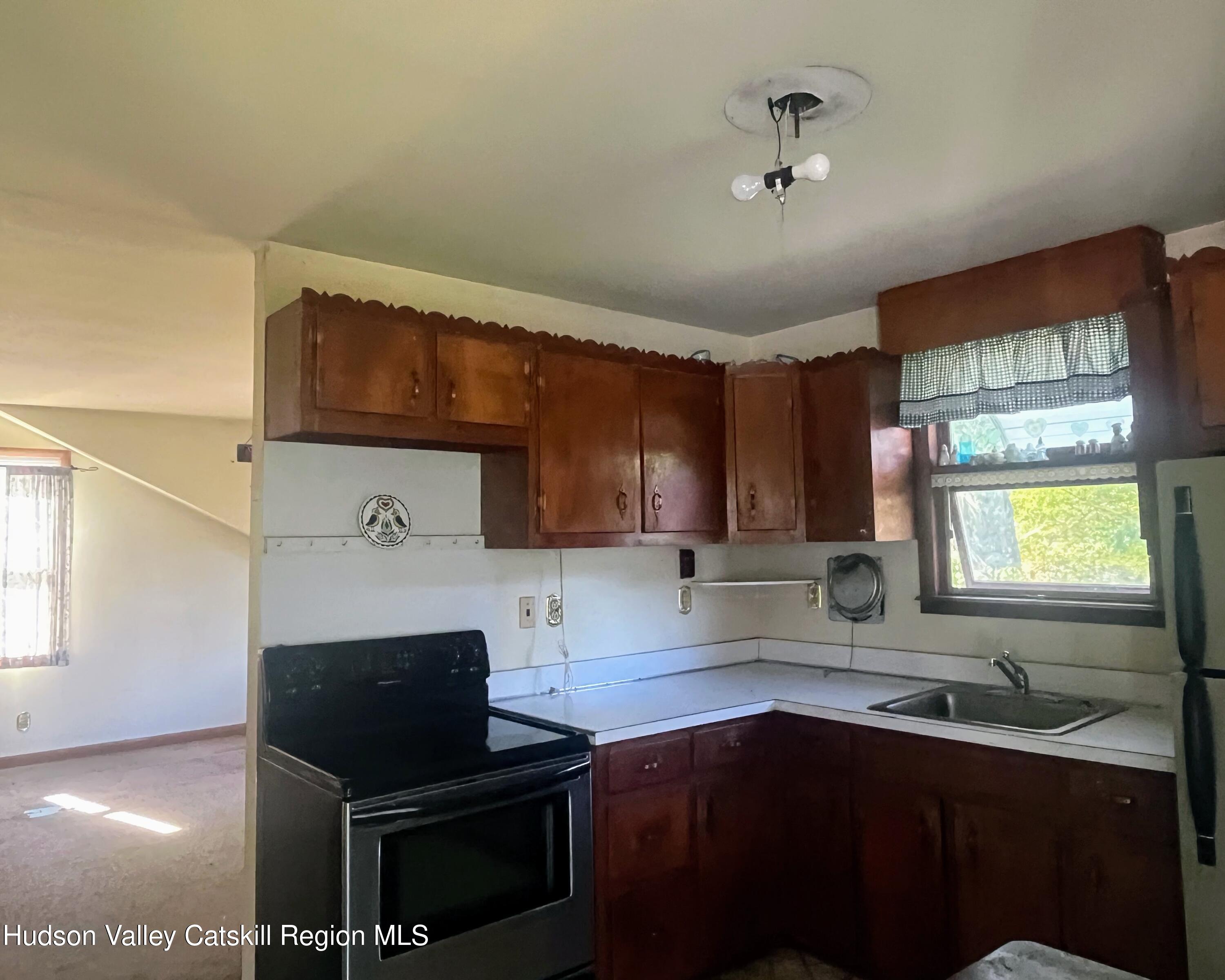 729 Springtown Road Tillson, NY 12486 - Photo 49 of 52 a kitchen with a sink a stove and cabinets