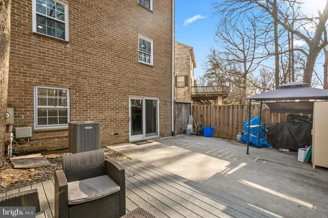 a view of a patio with couches table and chairs with wooden fence