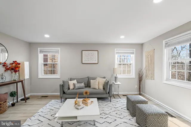 a living room with furniture a rug and a window