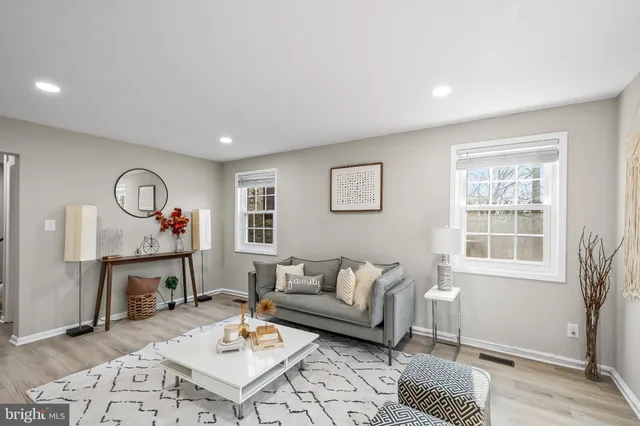a living room with furniture a rug and a window