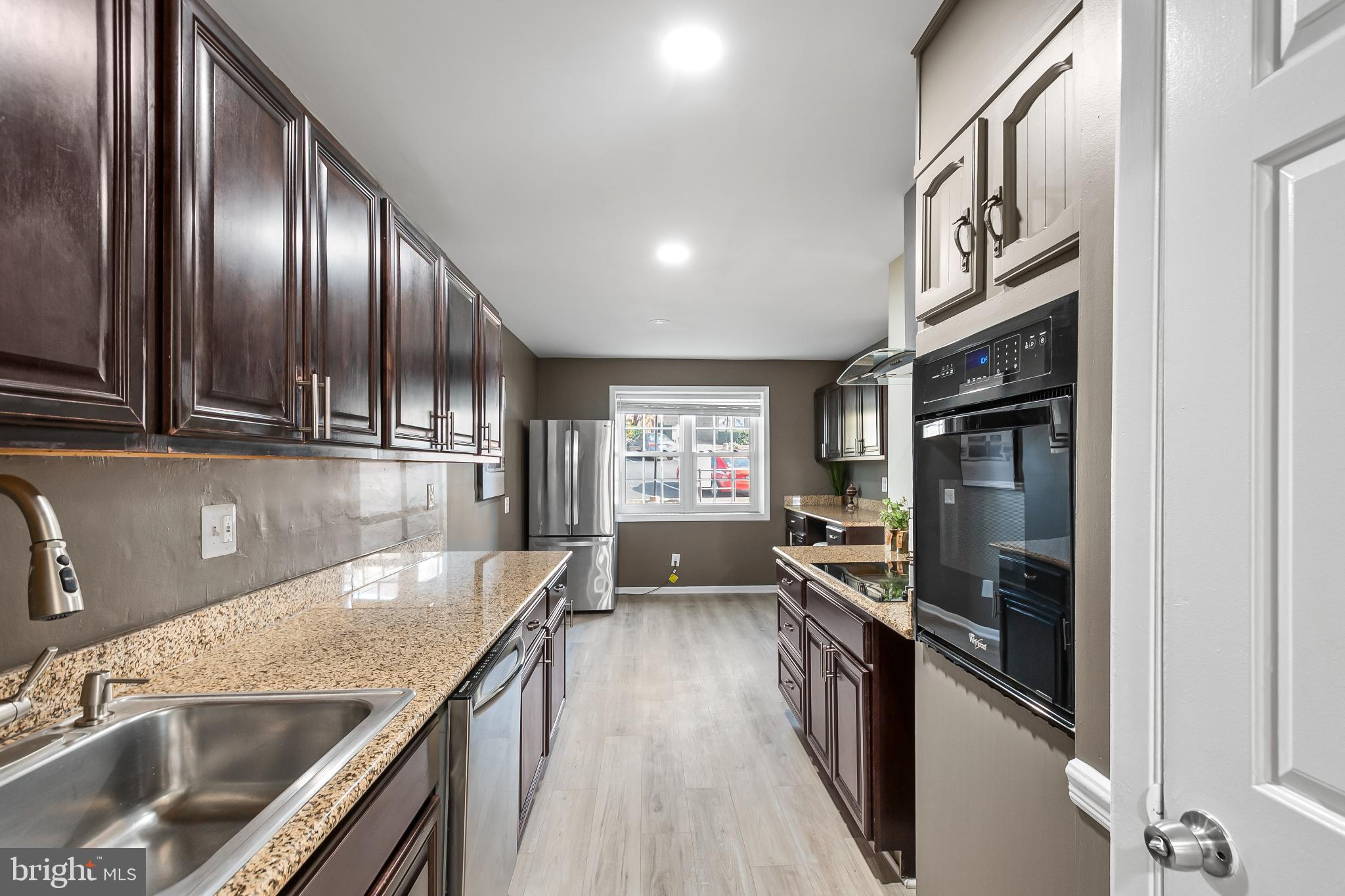 11867 Old Columbia Pike, Unit 75 Silver Spring, MD 20904 - Photo 10 of 41 a kitchen with granite countertop stainless steel appliances a sink stove top oven and cabinets