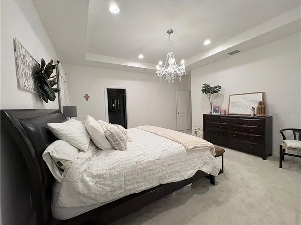 a bedroom with a bed and dresser with chair