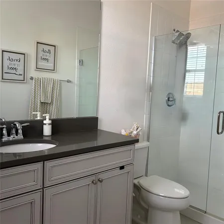 a bathroom with a granite countertop sink a toilet and a mirror