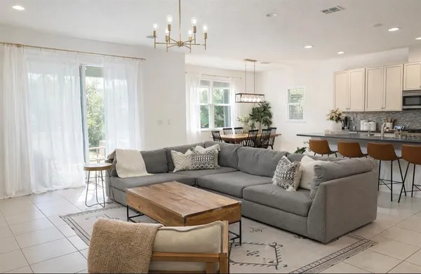 a living room with furniture wooden floor and a chandelier