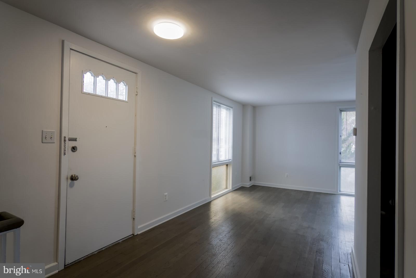 301 I Street Southwest, Unit 108 Washington, DC 20024 - Photo 11 of 66 an empty room with wooden floor and windows