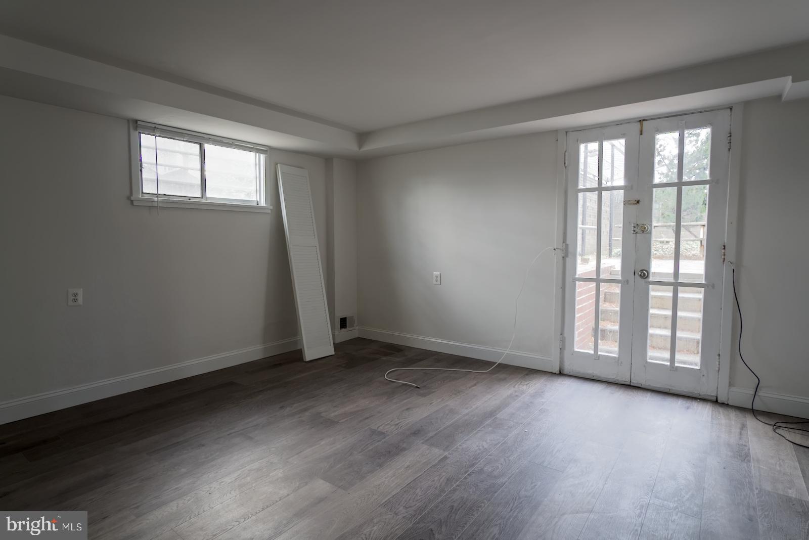 301 I Street Southwest, Unit 108 Washington, DC 20024 - Photo 15 of 66 an empty room with wooden floor and windows