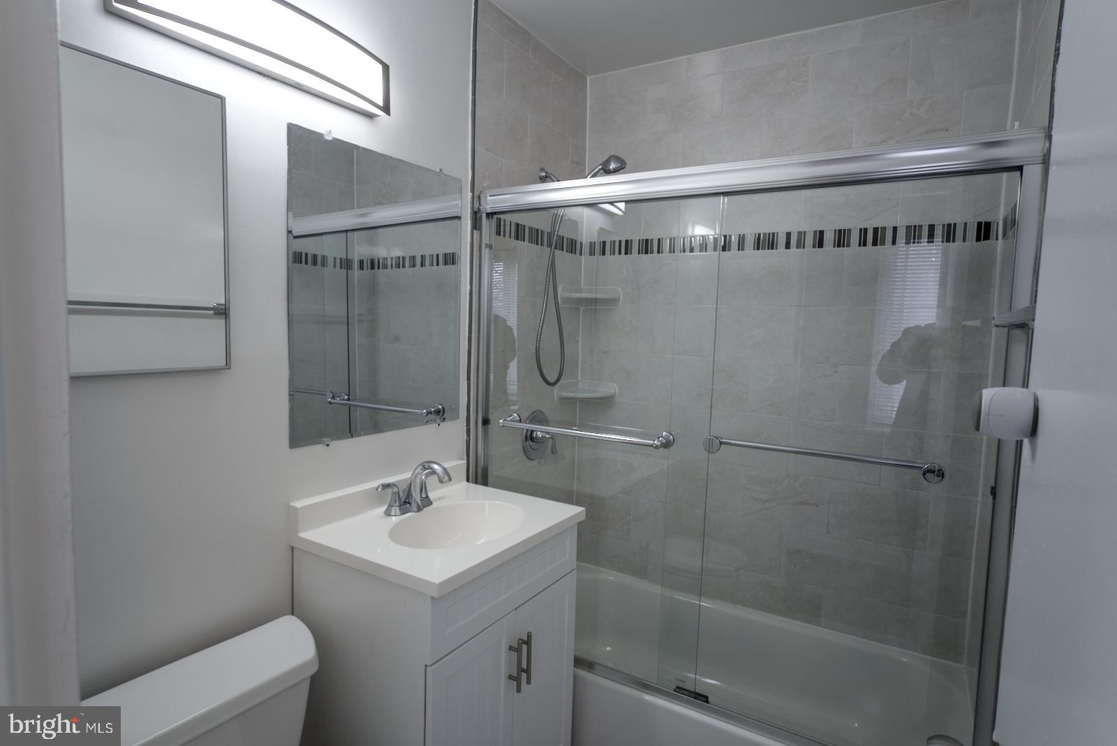 301 I Street Southwest, Unit 108 Washington, DC 20024 - Photo 23 of 66 a bathroom with a shower a mirror and a sink