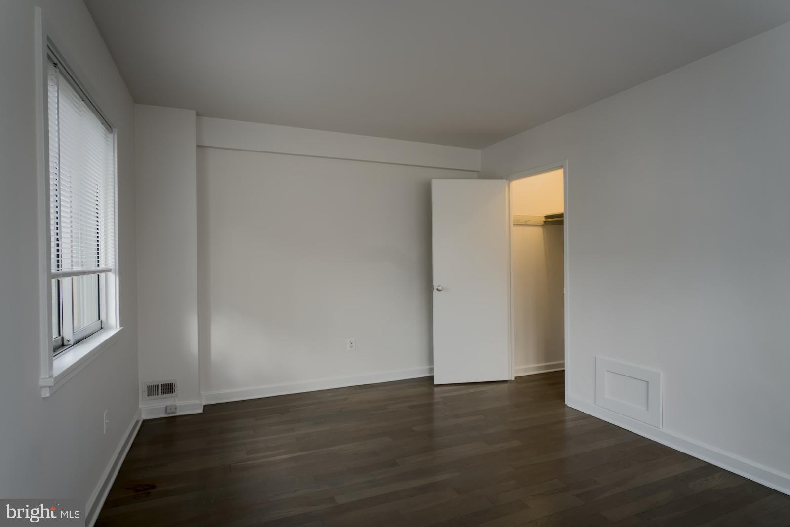 301 I Street Southwest, Unit 108 Washington, DC 20024 - Photo 24 of 66 an empty room with wooden floor and windows