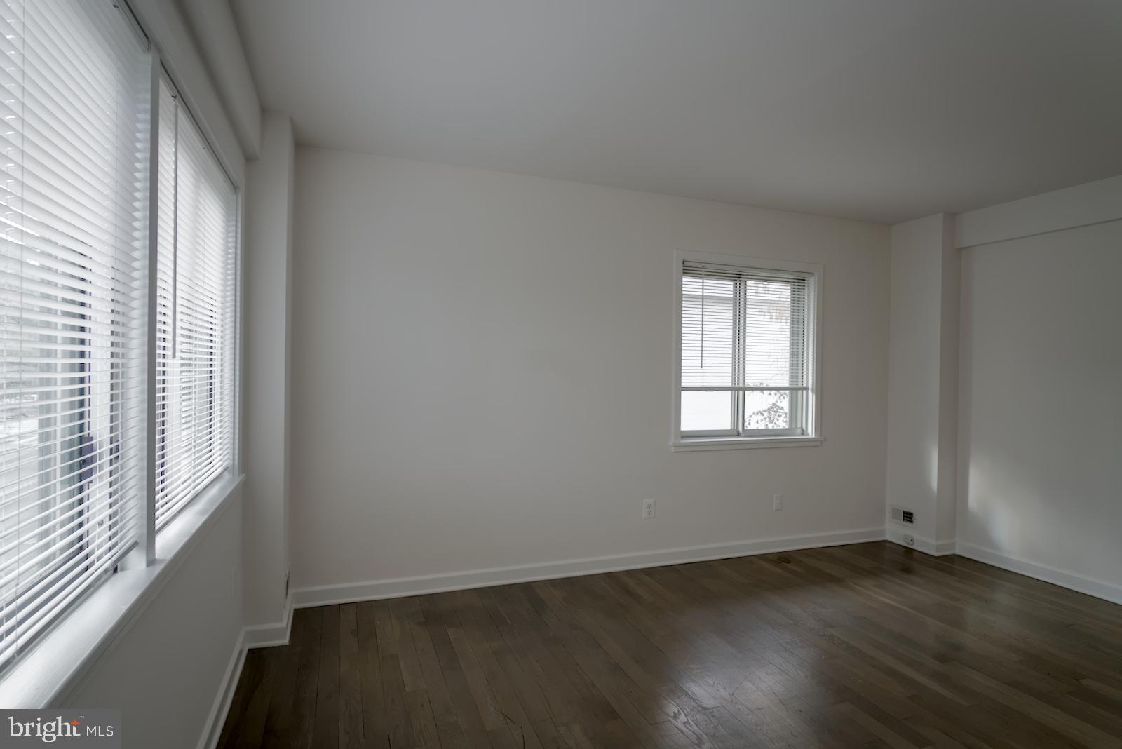 301 I Street Southwest, Unit 108 Washington, DC 20024 - Photo 25 of 66 an empty room with wooden floor and windows