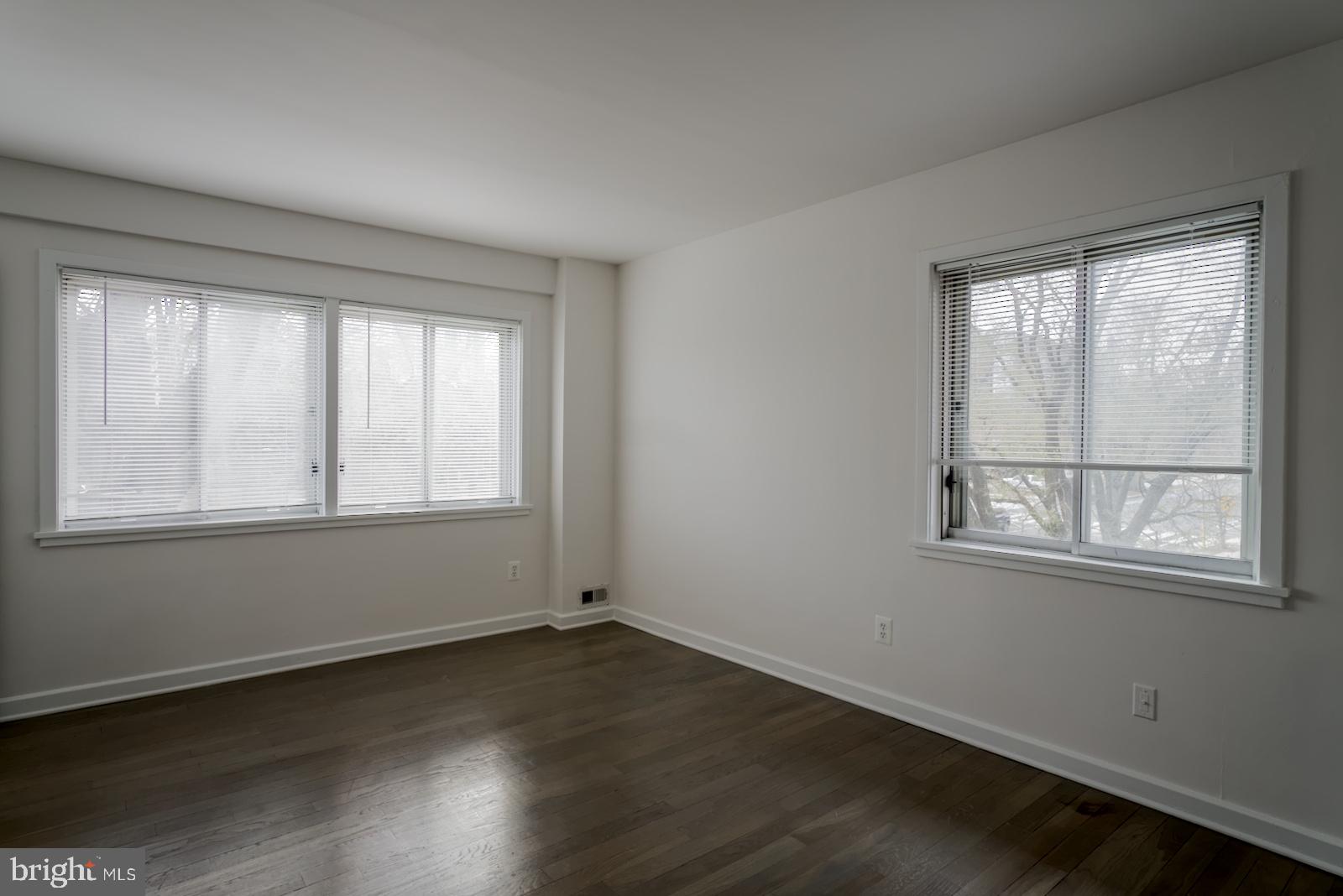 301 I Street Southwest, Unit 108 Washington, DC 20024 - Photo 26 of 66 an empty room with wooden floor and windows