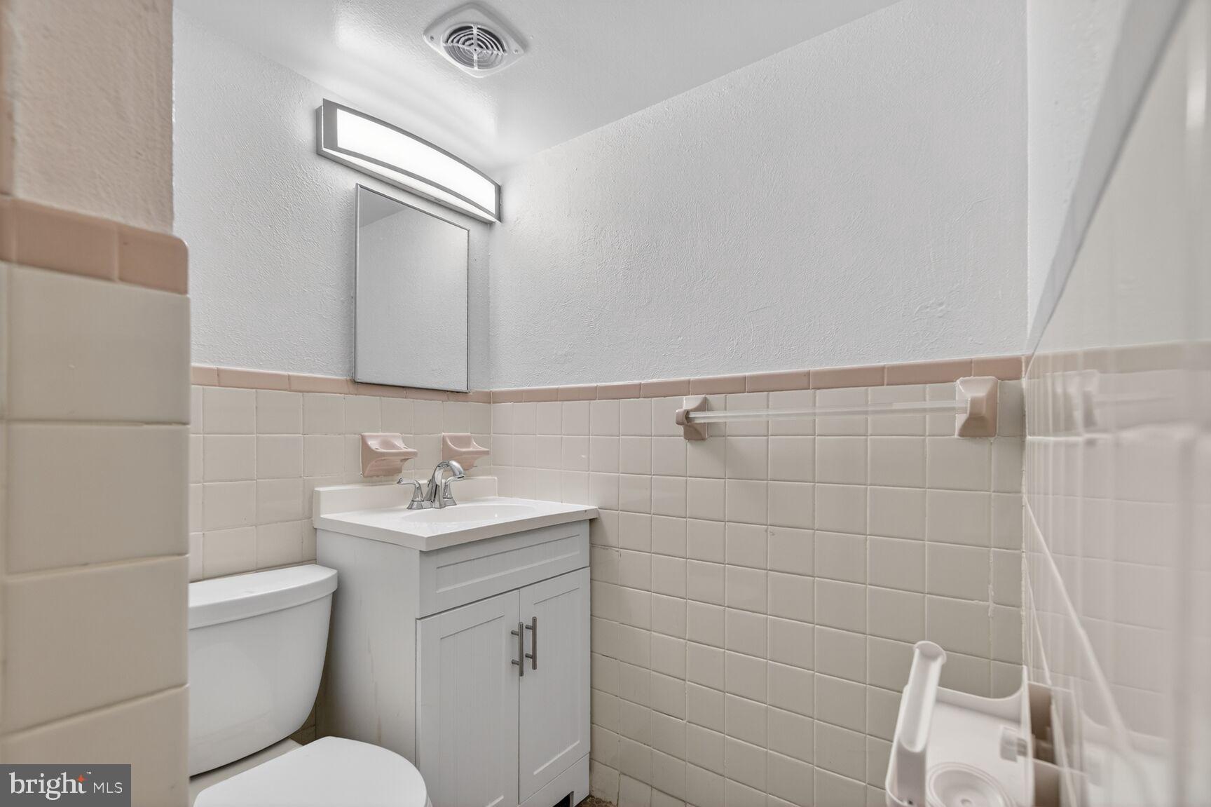 301 I Street Southwest, Unit 108 Washington, DC 20024 - Photo 32 of 66 a bathroom with a granite countertop toilet sink and mirror