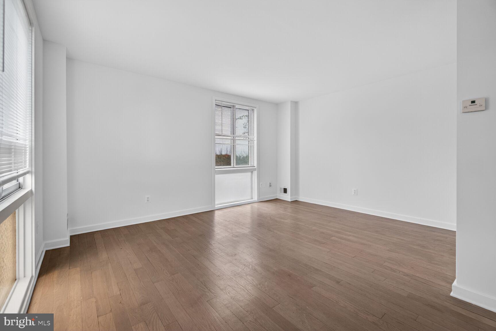 301 I Street Southwest, Unit 108 Washington, DC 20024 - Photo 35 of 66 an empty room with wooden floor and windows