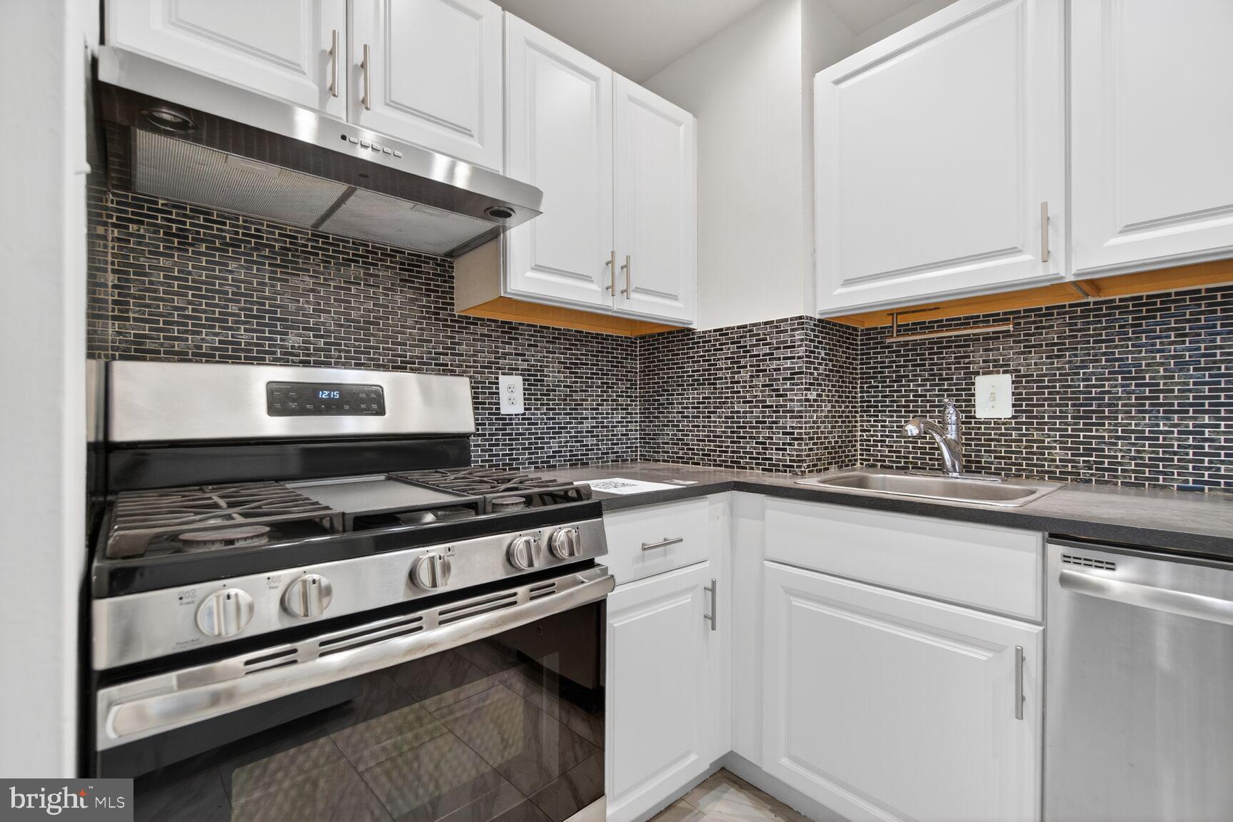 301 I Street Southwest, Unit 108 Washington, DC 20024 - Photo 37 of 66 a kitchen with white cabinets and appliances