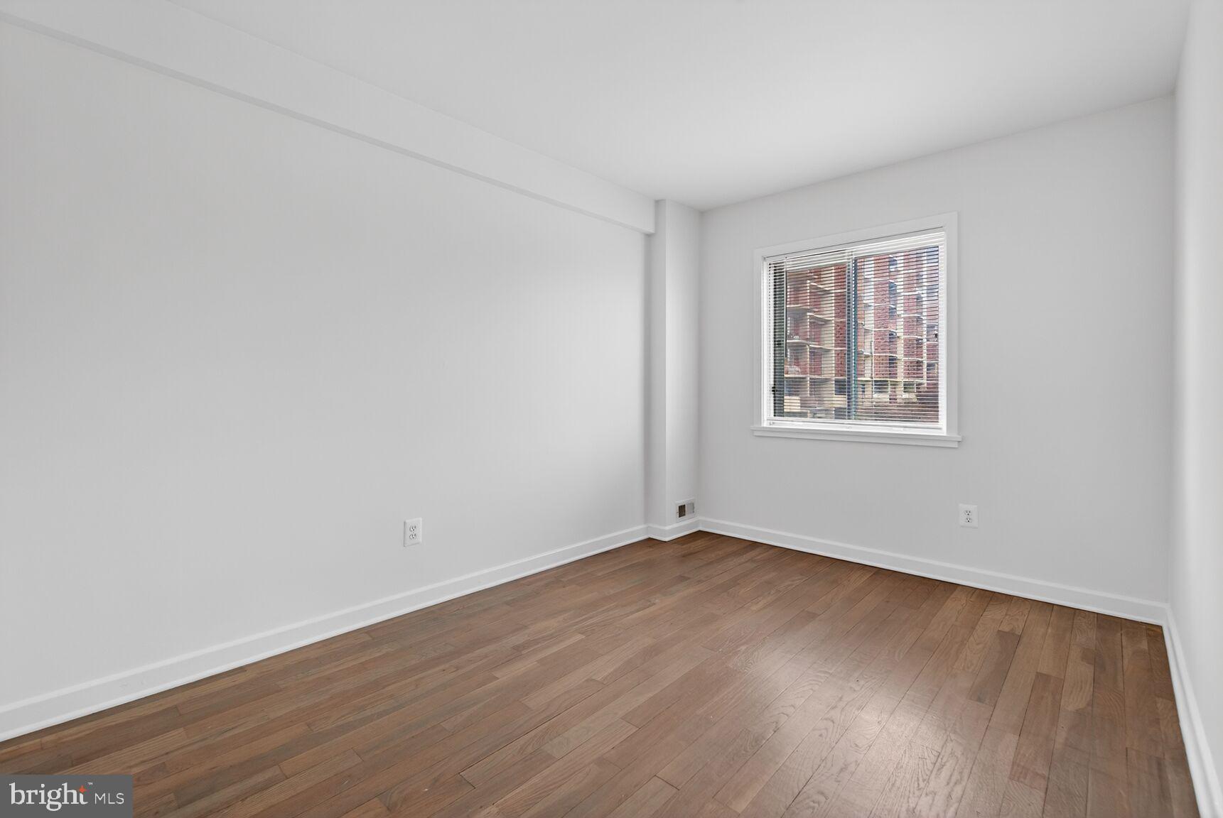 301 I Street Southwest, Unit 108 Washington, DC 20024 - Photo 42 of 66 a view of an empty room with wooden floor and a window
