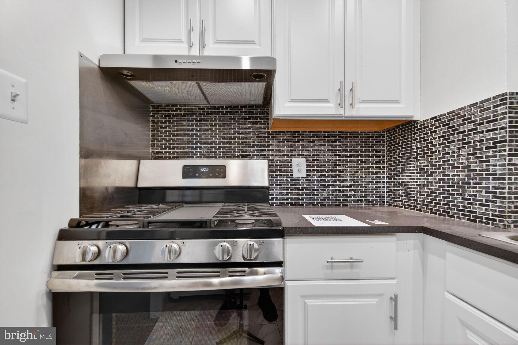 301 I Street Southwest, Unit 108 Washington, DC 20024 - Photo 45 of 66 a kitchen with white cabinets and black appliances
