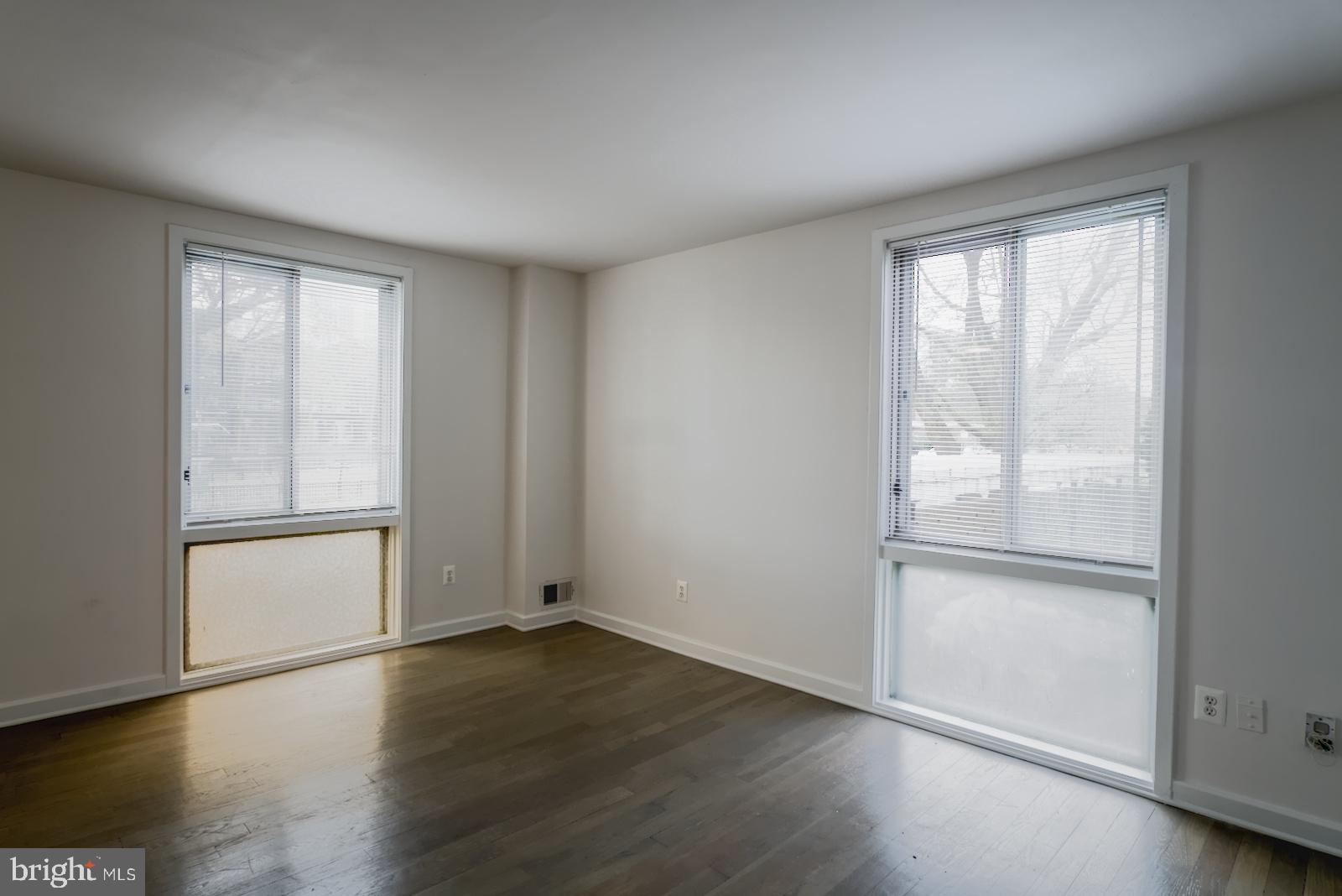 301 I Street Southwest, Unit 108 Washington, DC 20024 - Photo 9 of 66 an empty room with wooden floor and windows