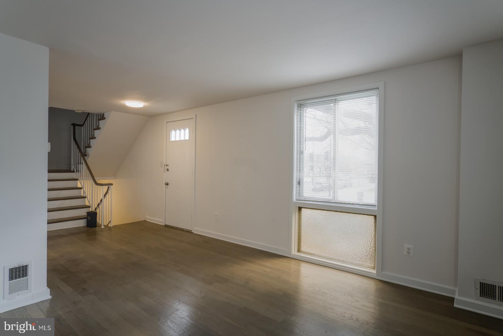 301 I Street Southwest, Unit 108 Washington, DC 20024 - Photo 10 of 66 an empty room with wooden floor and windows