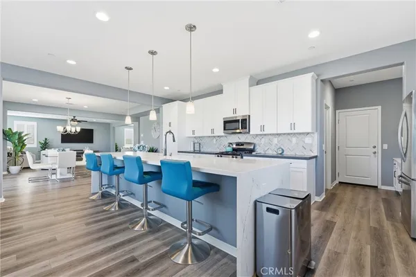 a large white kitchen with lots of counter space a sink appliances and cabinets