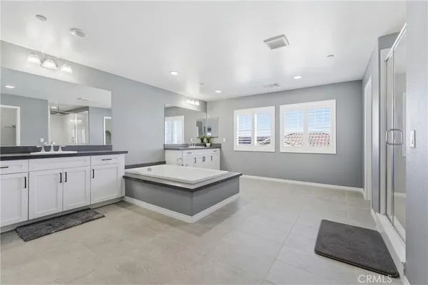 a spacious bathroom with a double vanity sink and mirror