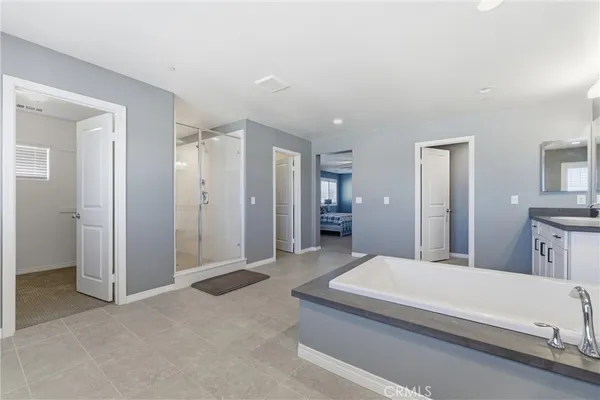 a spacious bedroom with a bed and a view of bathroom