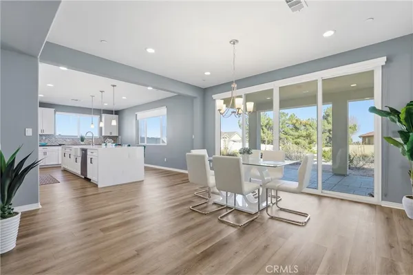 a living room with furniture and kitchen view with wooden floor
