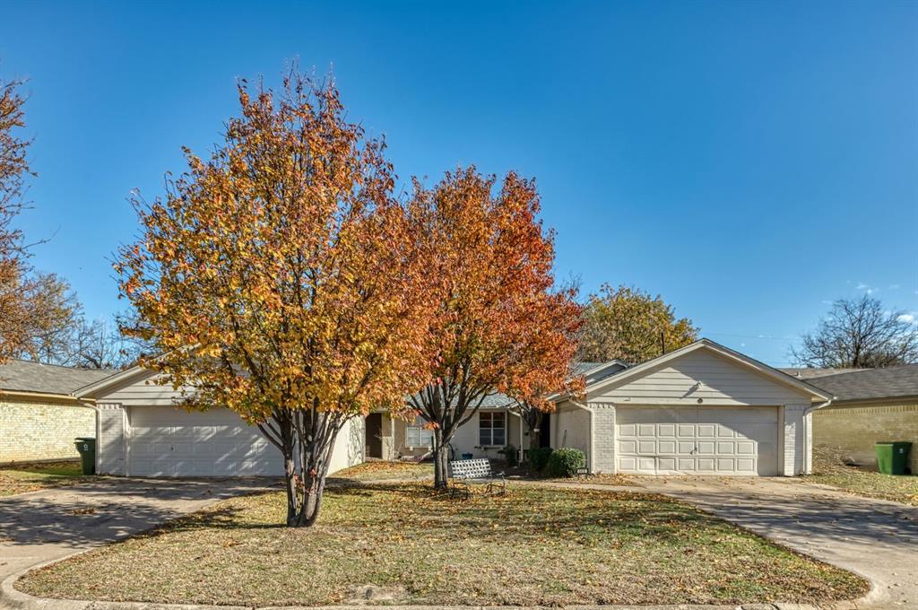 View of front of property featuring brick siding, concrete driveway, and a front lawn