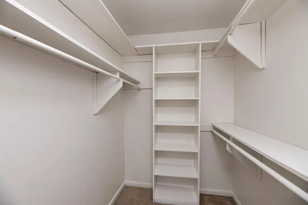 a view of walk in closet with empty racks