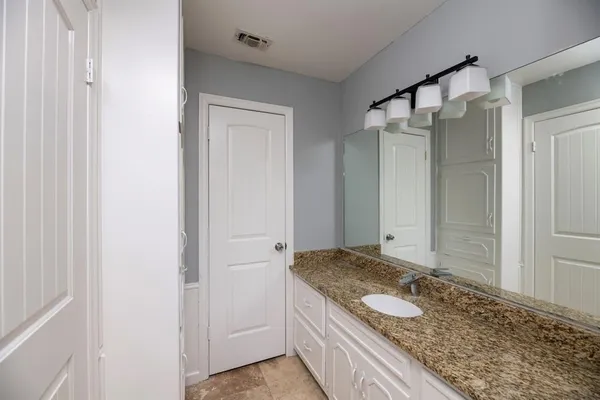 a bathroom with a granite countertop sink and shower