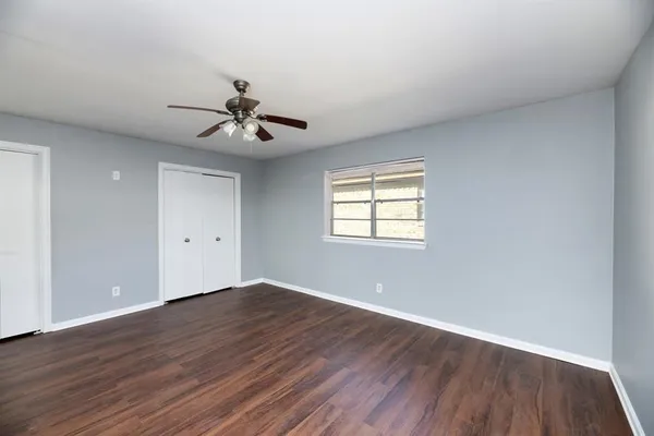 a view of a room with wooden floor and a ceiling fan