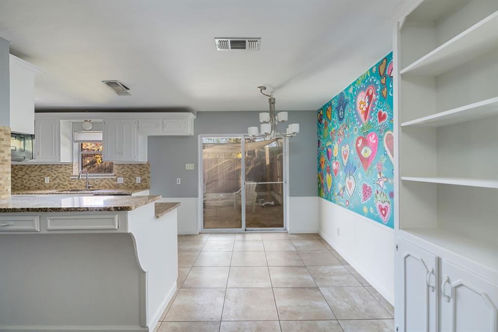 540 Billie Ruth Lane Hurst, TX 76053 - Photo 10 of 40 Kitchen with white cabinetry, dark stone countertops, a chandelier, wainscoting, and light tile patterned floors