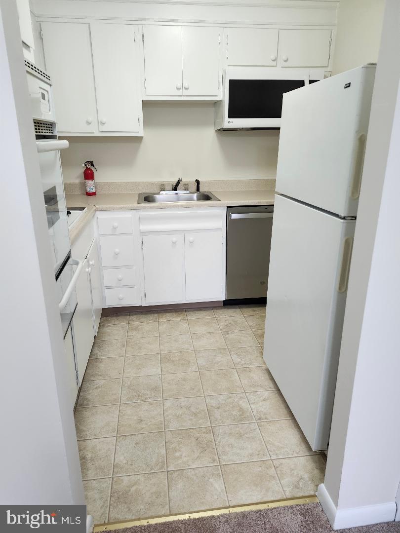 524 South Cedar Lane Upper Darby, PA 19082 - Photo 4 of 16 a kitchen with a sink a refrigerator a microwave and cabinets
