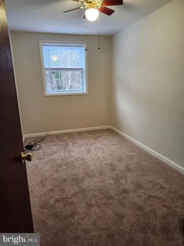 an empty room with a fan and a window
