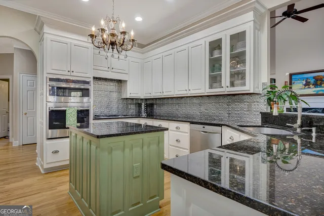 a kitchen with stainless steel appliances granite countertop a stove and cabinets